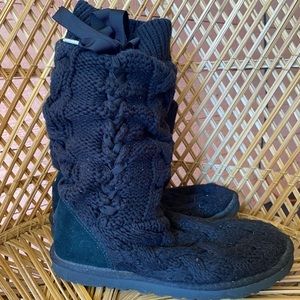 They are Ugg’s. Black knit with ribbon tie. Fuzzy inside of the foot. Like new